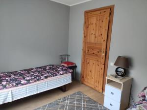 a bedroom with a bed and a wooden door at Vormsi Ohvitseride maja korter nr 6 in Hullo