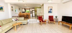 a living room with a couch and chairs and a table at Aquarius Kefalonia in Pesádha