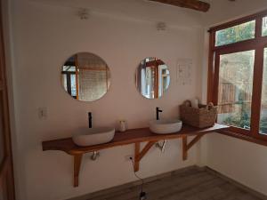 a bathroom with two sinks and two mirrors at Boana hotel in Palomino