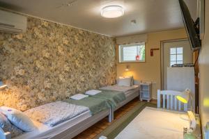 two beds in a room with floral wallpaper at Ämmamoori Maja - Mother-in-Law's House in Palmse