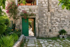 an entrance to a building with a green door and flowers at Apartments Subotic in Risan