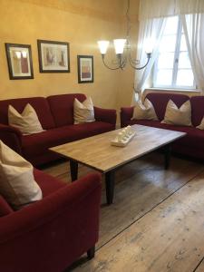 a living room with red couches and a wooden table at Altstadtmeise Elegance in Meisenheim