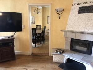 a living room with a fireplace and a flat screen tv at Altstadtmeise Elegance in Meisenheim