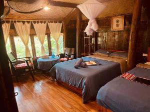 a bedroom with two beds and two tables at La Beauté Nghia Do in Nghĩa Ðô