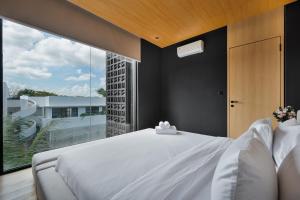 a bedroom with a white bed and a large window at M4YA Berawa in Canggu