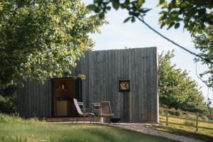 a tiny house with two chairs and a table at White House Hideaway in Brockhampton