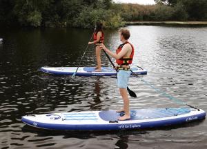 two people on paddle boards on the water at White House Hideaway in Brockhampton