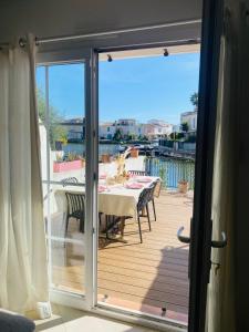 a sliding glass door leading to a deck with a table at Marina with pool in Aigues-Mortes