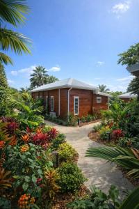 a house with atropical garden in front of it at Filao Cottage Bungalow avec Piscine Privée Proche plages in Sainte-Rose