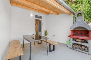 a patio with a table and a pizza oven at Charming Casa Piccola in Draga Bašćanska