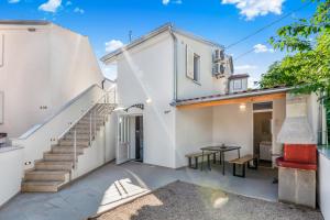 a view of the courtyard of a house with a table and stairs at Charming Casa Piccola in Draga Bašćanska