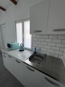 a white kitchen with a sink and a microwave at Hi Malpensa - Apartment in Case Nuove