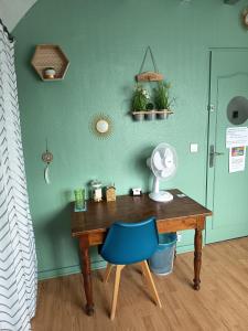 a room with a desk and a blue chair at Chambres d'hôtes des Bruyères in Collemiers
