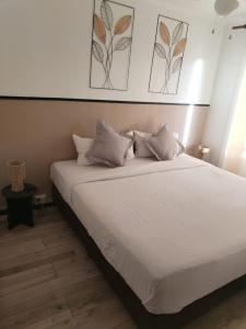 a bed with white sheets and pillows in a room at JenAlya in Vallauris