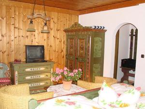 a living room with a tv and a table with chairs at Hotel Zur Erholung in Braunlage