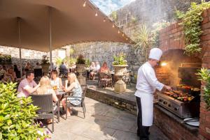 a chef preparing food in an outdoor restaurant at The Victoria Hotel in Galway