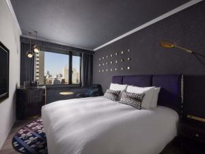 a bedroom with a large white bed and a window at Mercure Tokyo Hibiya in Tokyo