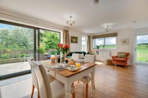 a dining room with a table and a living room at Gardener's Cottage in Alnwick