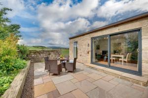 a patio with a table and chairs and a building at Gardener's Cottage in Alnwick