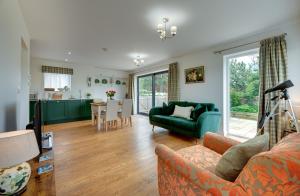 a living room with a green couch and a table at Gardener's Cottage in Alnwick