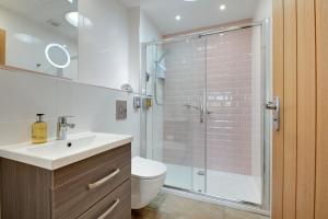 a bathroom with a shower and a toilet and a sink at Gardener's Cottage in Alnwick +33 photos
