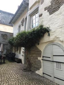 a stone building with a garage and a window at Altstadtmeise Rustika in Meisenheim