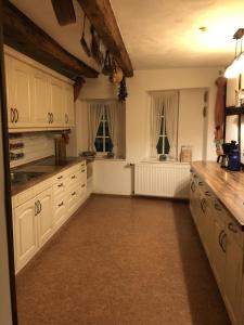 a large kitchen with white cabinets and windows at Altstadtmeise Rustika in Meisenheim