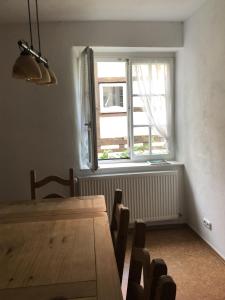 a dining room with a wooden table and a window at Altstadtmeise Rustika in Meisenheim