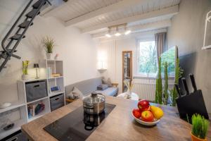 a kitchen with a table with a bowl of fruit on it at Tiny Loft Harz in Sankt Andreasberg +4 photos