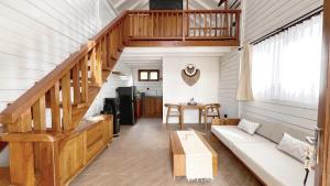 a living room with a couch and a staircase at Bacana Bungalows in Uluwatu