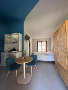 a bedroom with a bed and a table and chairs at Le Macerine in Castiglione del Lago
