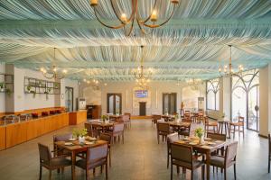 a restaurant with wooden tables and chairs and a blue ceiling at Rawai Luxury Tents Pushkar in Pushkar