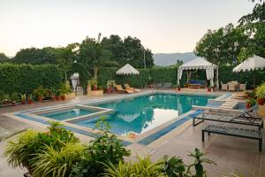 a swimming pool with two lounge chairs at Rawai Luxury Tents Pushkar in Pushkar