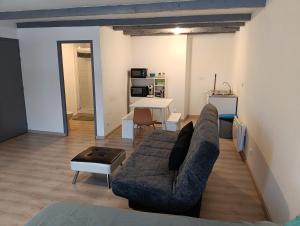 a living room with a couch and a table at Studios à la Campagne in Neuilly-lʼÉvêque