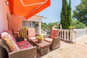 a patio with wicker chairs and a table at Hauzify I Casa Peralta in Les tres Cales