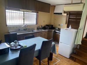 a kitchen with a table and a white refrigerator at 静佳民宿 in Osaka +14 photos