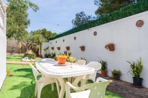 a patio with a white table and chairs at Hauzify I Casa Peralta in Les tres Cales