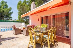 a patio with a table and chairs at Hauzify I Casa Peralta in Les tres Cales