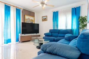 a living room with blue couches and a flat screen tv at Hauzify I Casa Peralta in Les tres Cales +28 photos