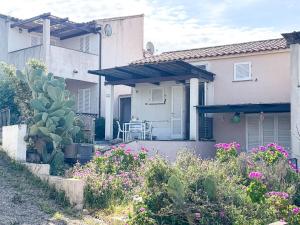 a house with a garden with flowers in front of it at Ostrica in Lumio