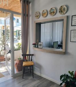 a mirror on a wall with a chair and plates at Hotel Garni Tosca in Lido di Jesolo