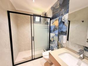 a bathroom with a shower and a toilet and a sink at Ida Hotel in Marmaris +40 photos