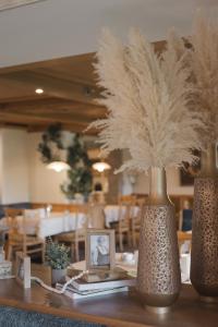 a table with two vases with feathers on it at Hotel Riedl in Kössen