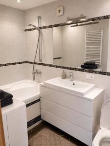 a bathroom with a sink and a tub and a mirror at Nikoletos apartamentai in Panevėžys
