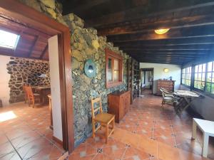 a room with a stone wall with a table and chairs at Casa Glorieta in Los Llanos de Aridane