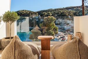 a room with two chairs and a large window at Casa Nina in Patitiri