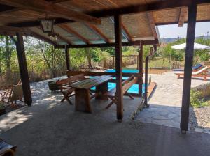a picnic table under a pavilion with a pool at villa vidalis in Veliko Golovode