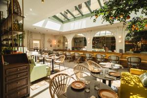 a restaurant with tables and chairs in a room at Hôtel Lepoussin in Cannes