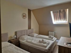 a bedroom with two beds with teddy bears on them at Hotel Korona in Siófok