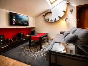 a living room with a couch and a red wall at Ático Centro Málaga in Málaga